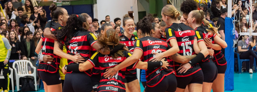 Jogadoras do Sesc RJ Flamengo comemoram em quadra durante partida de vôlei.